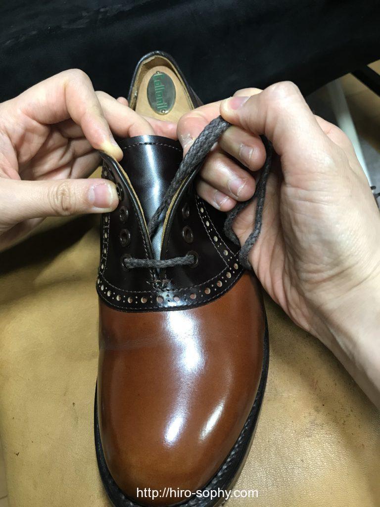 紐を締め直す革靴