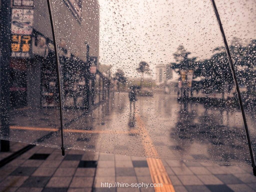 透明な傘が雨に濡れる